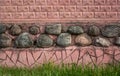 Red brick wall, stones in the middle