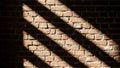 Red brick wall with sunlight casting diagonal shadows across its surface Royalty Free Stock Photo