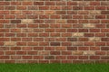 Red brick wall texture with green grass at the bottom Royalty Free Stock Photo
