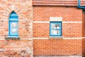 Red brick wall with two blue windows. Royalty Free Stock Photo