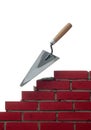 A red brick wall under construction features a trowel with a Royalty Free Stock Photo