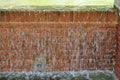 Red brick wall with water flowing from a fountain in the park. Spain Royalty Free Stock Photo