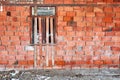 Red brick wall and window of an abandoned unfinished building in a construction site. Royalty Free Stock Photo