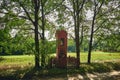 A red brick wayside shrine standing by a dirt road