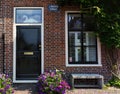 Red bricks house facade with window, door, bench and flowers Naarden Netherland Royalty Free Stock Photo