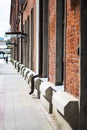 Red bricks houses and pedestrial road, defocused people seen from far away. Urban and industrial image. Vertical with