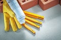 Red bricks protective gloves construction plans wooden meter on Royalty Free Stock Photo