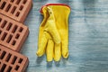 Red bricks protective gloves on wooden board top view building c Royalty Free Stock Photo