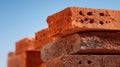 Red Bricks Stacked in Sunlight Against a Clear Blue Sky, Showcasing Their Texture and Color in a Construction Setting Royalty Free Stock Photo