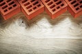 Red bricks on wooden board top view bricklaying concept Royalty Free Stock Photo