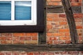 Red bricks on a wooden half timbered house and a window with shutter Royalty Free Stock Photo