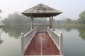 Red bridge connect between white pavilion in mash and land. Royalty Free Stock Photo