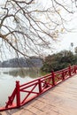 Red Bridge at Hoan Kiem Lake with tress and reflected shadow and branches in foreground in Hanoi, Vietnam
