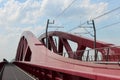 Red bridge over river IJssel in Zwolle for trains and with seperate cycle lane in the Netherlands.