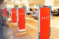 Red bright sale banner on anti-thieft gate sensor at retail shopping mall entrance. Seasonal discount offer in store