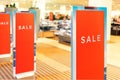 Red bright sale word banner on anti-thieft gate sensor at retail shopping mall entrance. Seasonal discount offer in Royalty Free Stock Photo