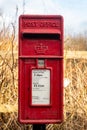 Red British Royal Mail, Lamp Post office box in a rural setting Royalty Free Stock Photo