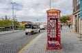 Red British telephone kiosk covered in graffiti in Porto, Portugal