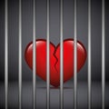 Red broken heart in a jail on dark background