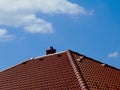 Brown clay tile sloped pitched roof. blue sky and white clouds. Royalty Free Stock Photo