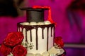Red and brown graduation cake with cap on the top and red rose on side Royalty Free Stock Photo