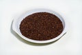 Red or brown Sesame seeds isolated in a pot on white background