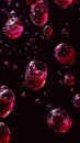 Red bubbles of various sizes suspended in dark liquid, captured in macro photography style, on black background. Concept of Royalty Free Stock Photo