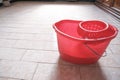 Red bucket of cleaning on the tiled floor ready to clean close-up. Cleaning services. Home interior Royalty Free Stock Photo