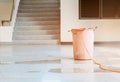 Red bucket underlie water leak interior office building in from Ceiling Royalty Free Stock Photo