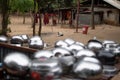 Red buddhist robes hanging and shiny alms bowls drying with two young monks in the background Royalty Free Stock Photo