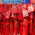 Red buddhists praying and hanging traditional wishing cards