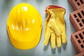 Red building bricks protective hard hat leather safety gloves on Royalty Free Stock Photo