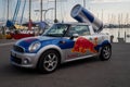 Red Bull advertising Mini Cooper car with logo. Giant Red Bull energy drink can on the car\'s roof