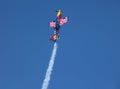 A Red Bull stunt plane trailing smoke during an aerobatic display. Royalty Free Stock Photo