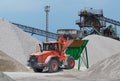 Red bulldozer at work on a green hopper under the conveyor belts in a gravel pit Royalty Free Stock Photo