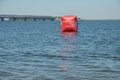 Red buoy on blue water with the name of the marathon. Royalty Free Stock Photo