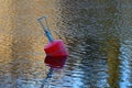 A red buoy floats on the surface of the lake Royalty Free Stock Photo