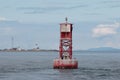 Red buoy with Point Wilson Lighthouse backdrop Royalty Free Stock Photo