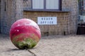 Red Buoy Pulled Onshore and Resting Beside the Beach Office Royalty Free Stock Photo