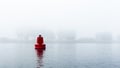 Red buoy in a river in the mist Royalty Free Stock Photo