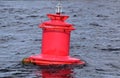 Red buoy on the undulating surface of the river. Lantern at the top of the buoy Royalty Free Stock Photo