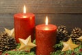 Rustic Christmas background with red burning candles and gold stars Royalty Free Stock Photo