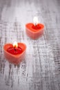 Red burning heart shaped candles on rustic white wooden table Royalty Free Stock Photo