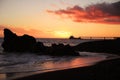 Red burning sunset at black sandy beach with single boat Royalty Free Stock Photo