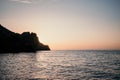 A red burning sunset over the sea with rocky volcanic cliff. Abstract nature summer or spring ocean sea background. Royalty Free Stock Photo