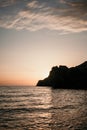 A red burning sunset over the sea with rocky volcanic cliff. Abstract nature summer or spring ocean sea background. Royalty Free Stock Photo