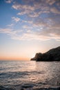 A red burning sunset over the sea with rocky volcanic cliff. Abstract nature summer or spring ocean sea background. Royalty Free Stock Photo