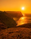 A red burning sunset with the silhouett of a cliff and castle over the sea Royalty Free Stock Photo