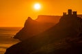 A red burning sunset with the silhouett of a cliff and castle over the sea Royalty Free Stock Photo