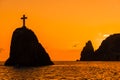 A red burning sunset with the silhouett of a cliff over the sea